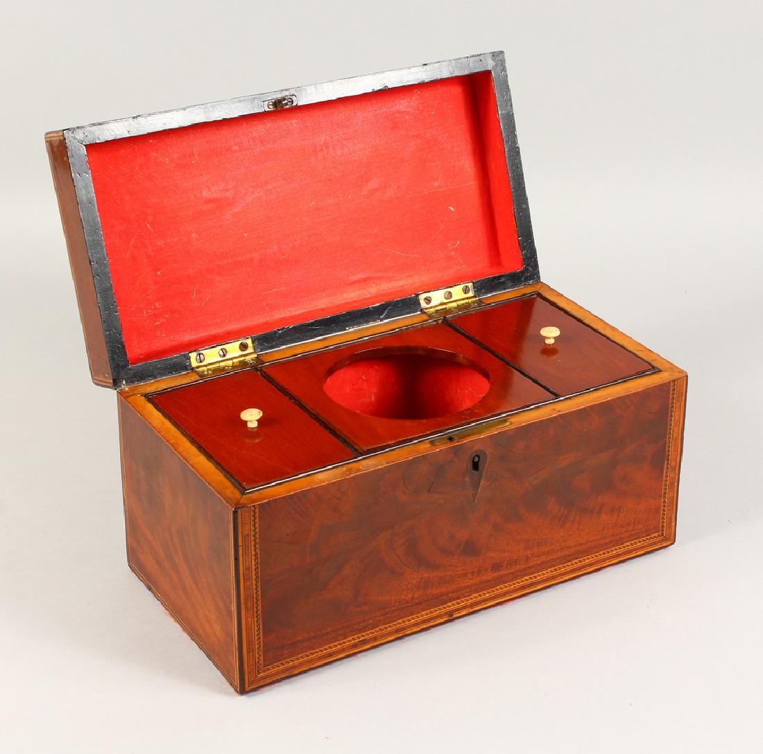 A GEORGE III MAHOGANY AND INLAID TEA CADDY, the: A GEORGE III MAHOGANY AND INLAID TEA CADDY, the interior with two lidded compartments and mixing bowl aperture (bowl lacking). 12ins wide.