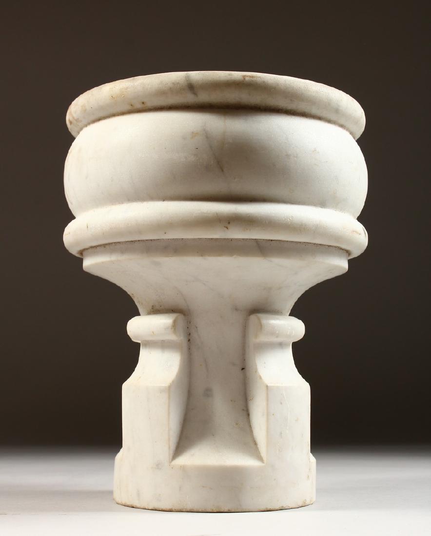 A CARVED WHITE MARBLE MORTAR, in the style of a font.: A CARVED WHITE MARBLE MORTAR, in the style of a font. 9ins high.