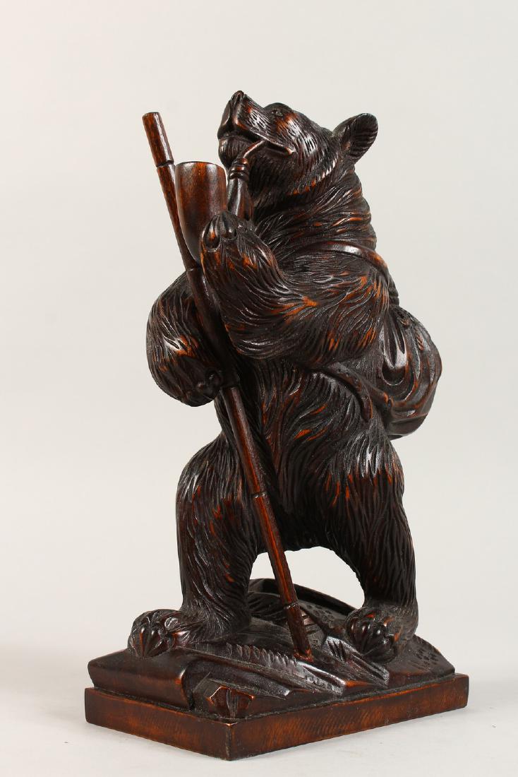 A BLACK FOREST STYLE CARVING of a bear smoking a pipe.: A BLACK FOREST STYLE CARVING of a bear smoking a pipe. 12ins high.