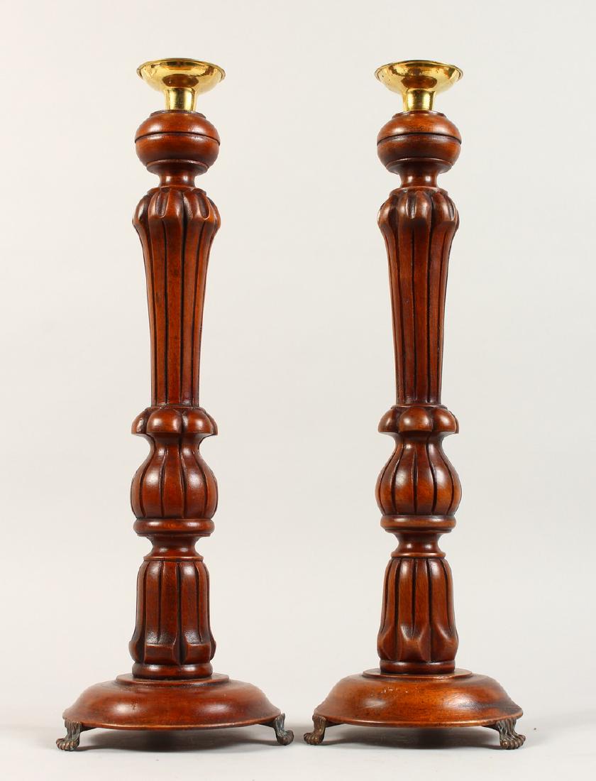 A PAIR OF TURNED WOOD CANDLESTICKS. 17ins high.: A PAIR OF TURNED WOOD CANDLESTICKS. 17ins high.