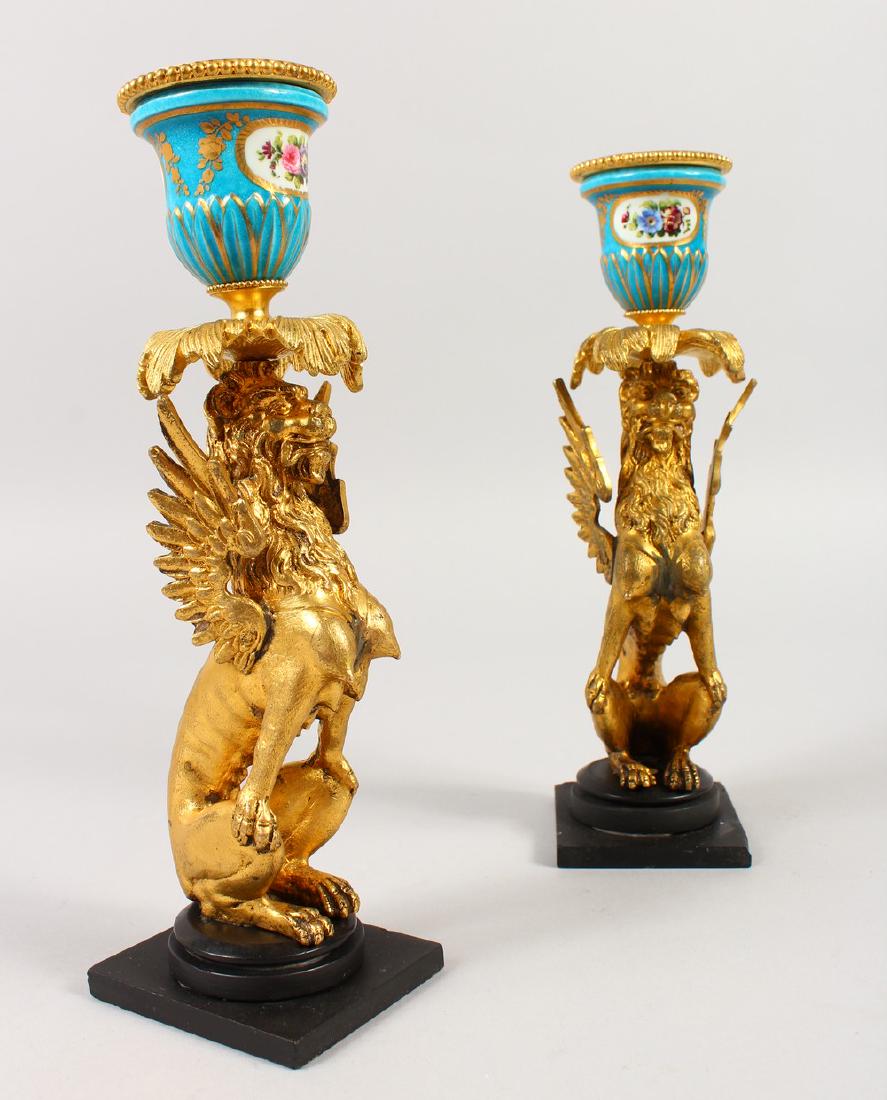 A GOOD PAIR OF FRENCH SEVRES PORCELAIN AND ORMOLU: A GOOD PAIR OF FRENCH SEVRES PORCELAIN AND ORMOLU WINGED LION CANDLESTICKS. 9ins high.