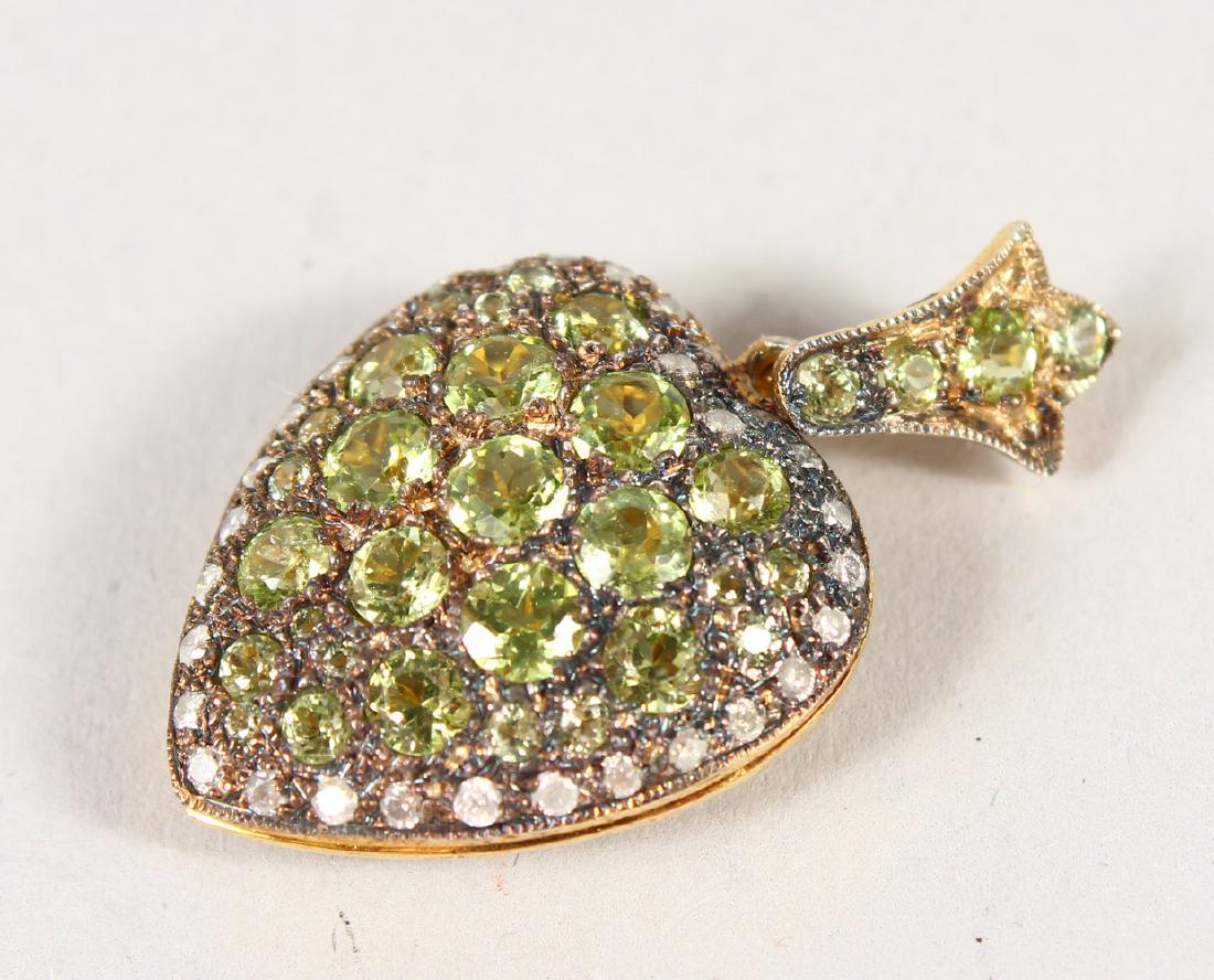 A 9CT GOLD AND SILVER PERIDOT AND DIAMOND HEART SHAPE: A 9CT GOLD AND SILVER PERIDOT AND DIAMOND HEART SHAPE LOCKET.