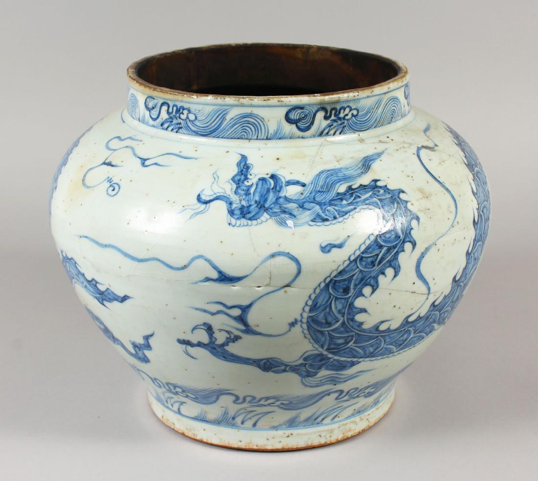 A CHINESE YUAN STYLE BLUE & WHITE PORCELAIN DRAGON JAR,: A CHINESE YUAN STYLE BLUE & WHITE PORCELAIN DRAGON JAR, the base unglazed, 32.5cm wide at widest point, 25.6cm high.