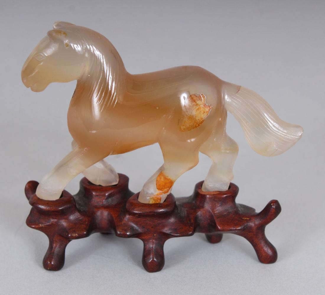 A SMALL 20TH CENTURY CHINESE AGATE MODEL OF A HORSE,: A SMALL 20TH CENTURY CHINESE AGATE MODEL OF A HORSE, together with a fitted wood stand, 6.3cm high overall, the agate itself 6.9cm long & 4.5cm high.