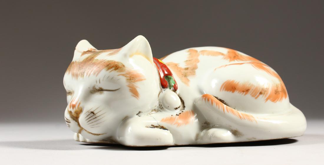 A 20TH CENTURY JAPANESE KUTANI PORCELAIN MODEL OF A: A 20TH CENTURY JAPANESE KUTANI PORCELAIN MODEL OF A SLEEPING CAT, the base unglazed, 7in long & 3.1in high.