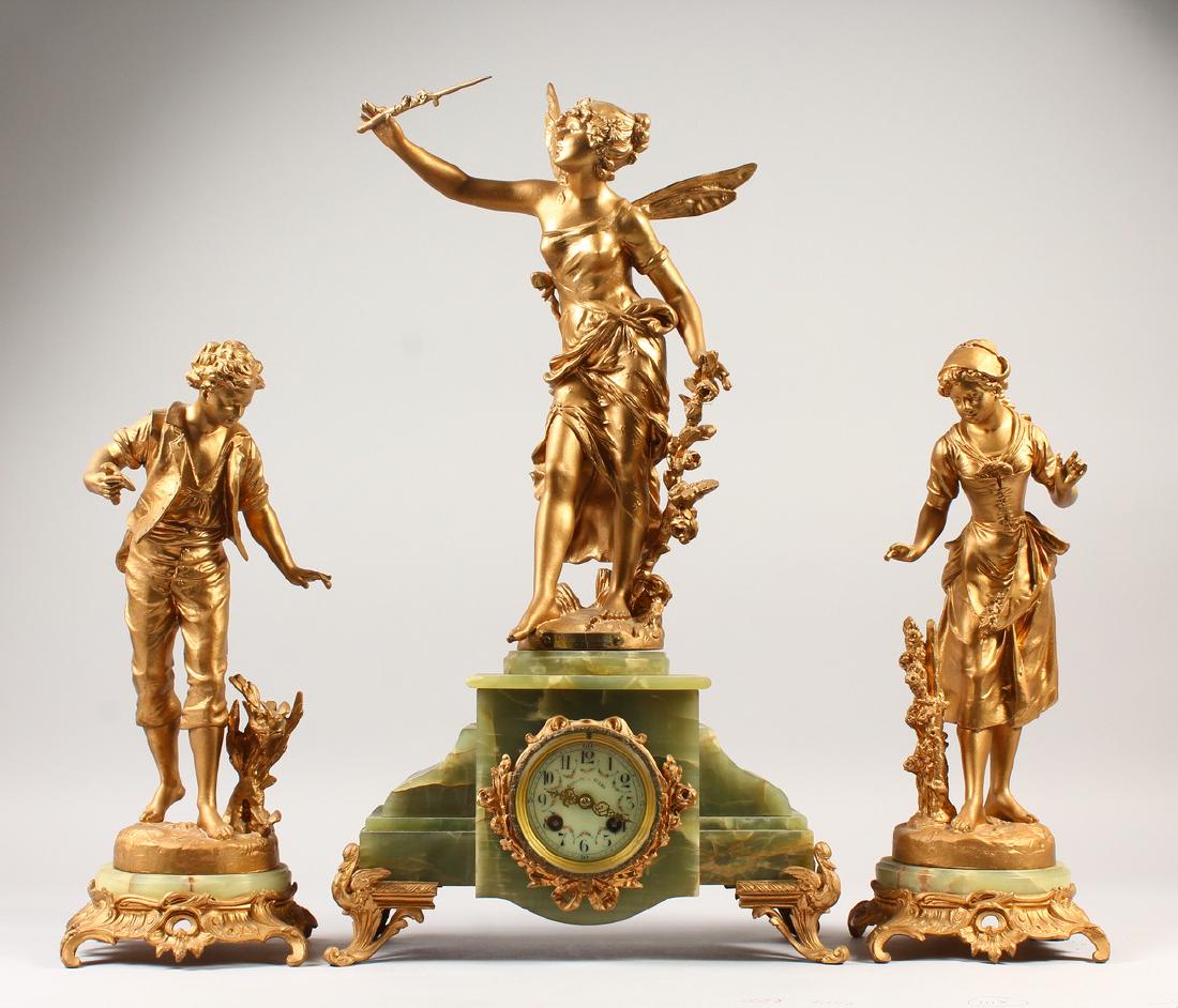 A 19TH CENTURY FRENCH ONYX AND GILT METAL GARNITURE DE: A 19TH CENTURY FRENCH ONYX AND GILT METAL GARNITURE DE CHEMINEE, comprising clock with winged female, along with a pair of side pieces, young boy and girl. Clock: 60cms high. Retailed by GIBSON & CO L