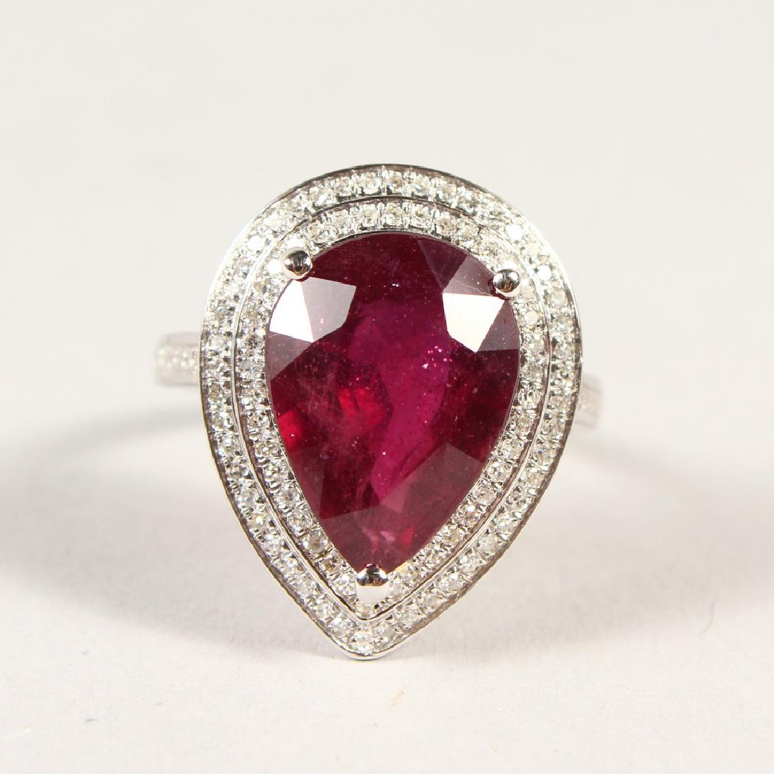 A 14K WHITE GOLD AND DIAMOND RING, set with a pear cut: A 14K WHITE GOLD AND DIAMOND RING, set with a pear cut ruby approx. 7.43ct, diamonds approx. 0.60ct total weight.