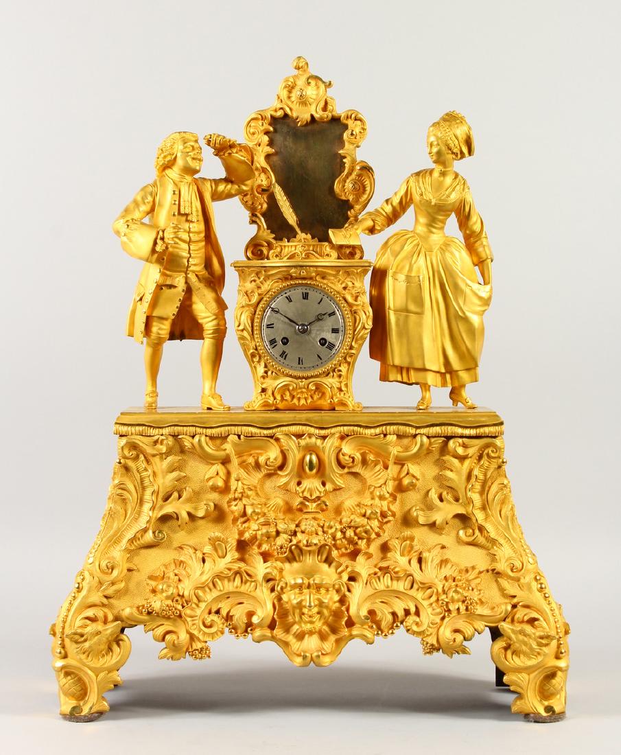 A SUPERB LARGE FRENCH ORMOLU MANTLE CLOCK, the drum: A SUPERB LARGE FRENCH ORMOLU MANTLE CLOCK, the drum movement in a case with a man and woman, with a letter and quill, the base of the clock with masks, swags and animal heads. 61cms high.