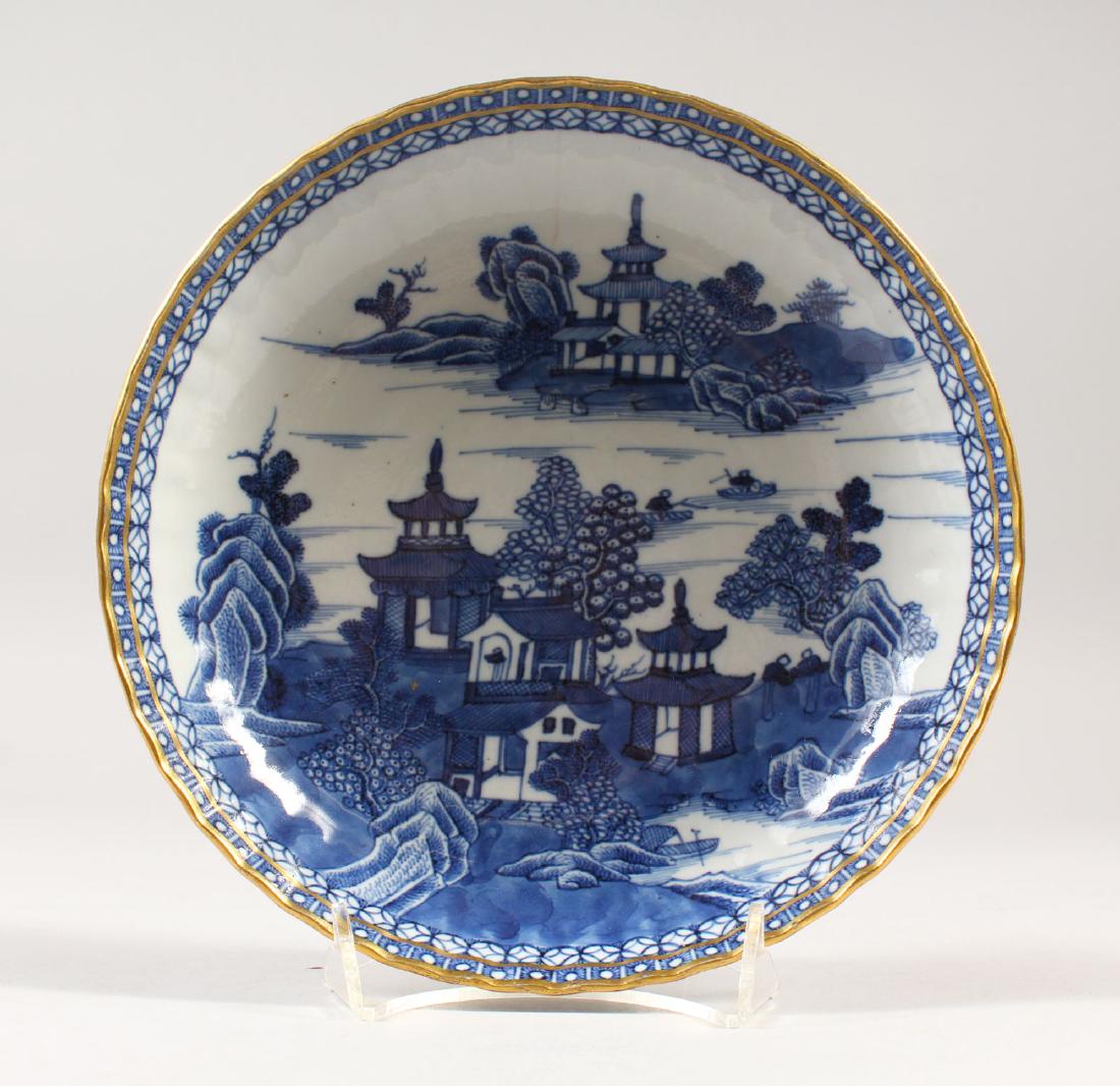 A 19TH CENTURY CHINESE BLUE & WHITE PORCELAIN DISH,: A 19TH CENTURY CHINESE BLUE & WHITE PORCELAIN DISH, decorated with gilt highlights to rim border, with scenes of temples and foliage, 20.6cm diameter.