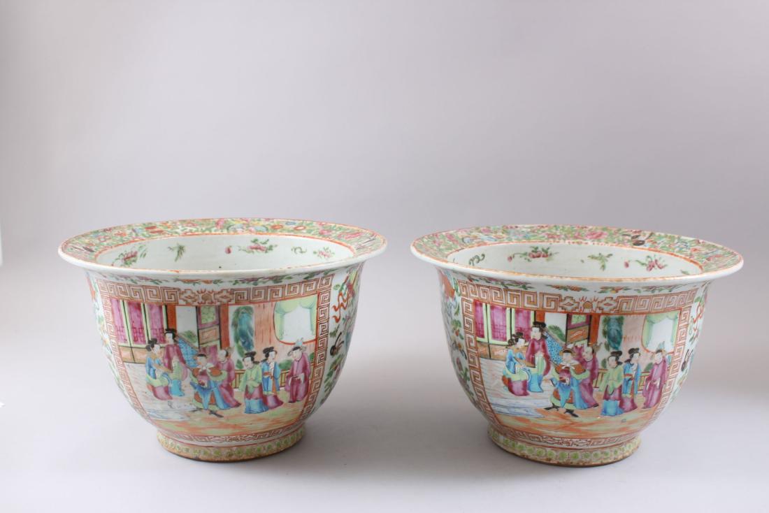 A PAIR OF 19TH CENTURY CHINESE CANTON FAMILLE ROSE: A PAIR OF 19TH CENTURY CHINESE CANTON FAMILLE ROSE PORCELAIN JARDINIERE'S, both with two panels depicting ladies stood interior surrounded by Greek key border designs, to further scalloped panels depi