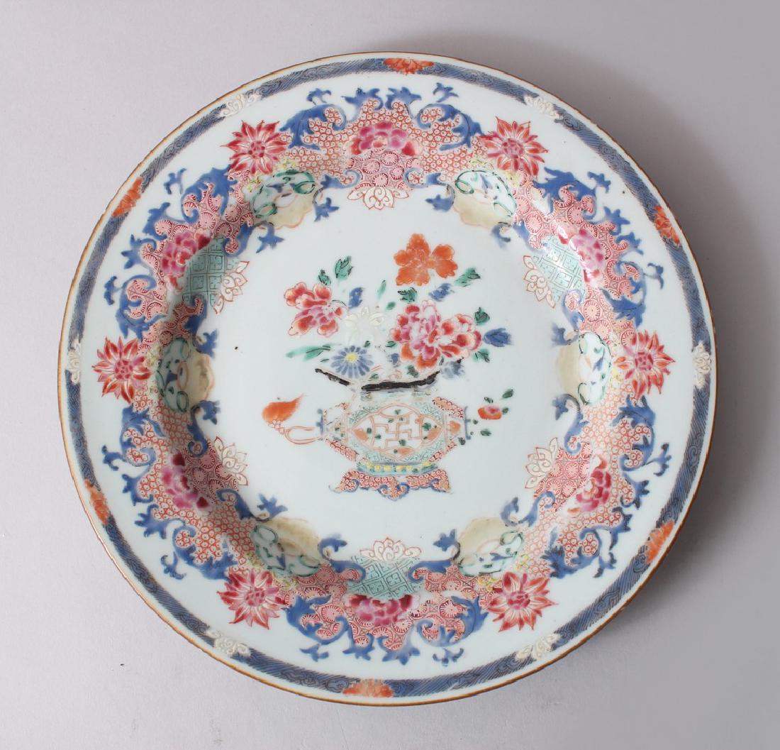 A CHINESE YONGZHENG FAMILLE ROSE PORCELAIN PLATE,: A CHINESE YONGZHENG FAMILLE ROSE PORCELAIN PLATE, decorated profusely with scrolling vine and flora, 23cm diameter.