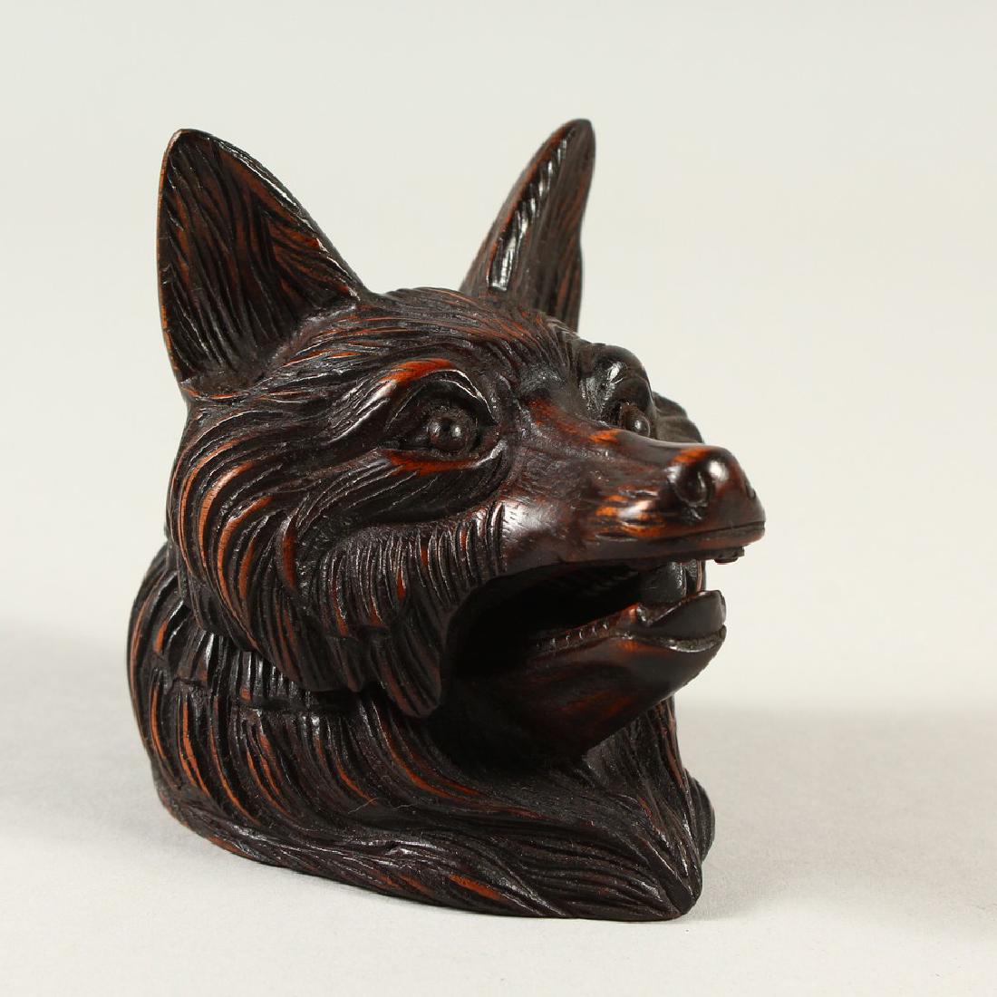 A BLACK FOREST STYLE CARVED WOOD FOXES HEAD INKWELL.: A BLACK FOREST STYLE CARVED WOOD FOXES HEAD INKWELL. 9cms high.
