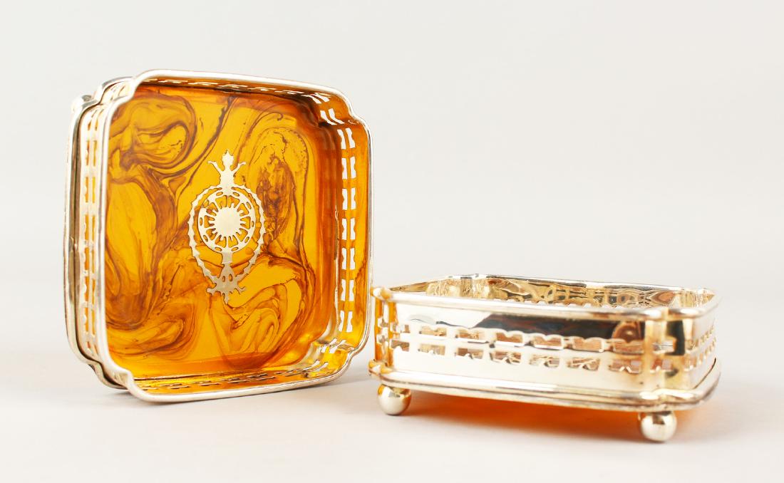 A PAIR OF FAUX TORTOISESHELL SQUARE COASTERS on bun: A PAIR OF FAUX TORTOISESHELL SQUARE COASTERS on bun feet. 12cms.