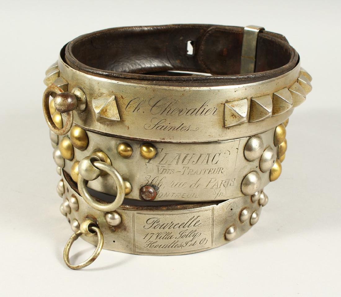 THREE 18TH CENTURY FRENCH LEATHER, METAL MOUNTED AND: THREE 18TH CENTURY FRENCH LEATHER, METAL MOUNTED AND STUDDED DOG COLLARS, with inscription and names. 17cms, 18cms and 19cms diameter.