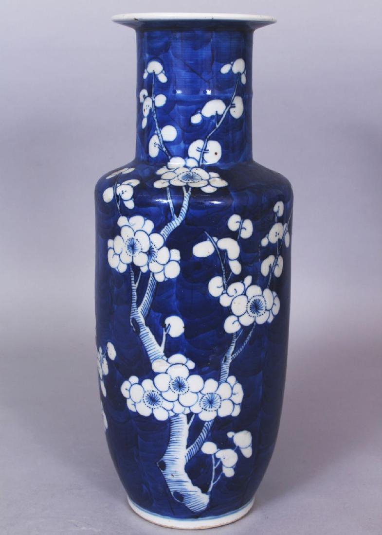 A 19TH CENTURY CHINESE BLUE & WHITE ROULEAU PORCELAIN: A 19TH CENTURY CHINESE BLUE & WHITE ROULEAU PORCELAIN VASE, the sides painted with prunus blossom reserved in white against a blue-wash crackled-ice ground, the base with a four-character Kangxi mark,