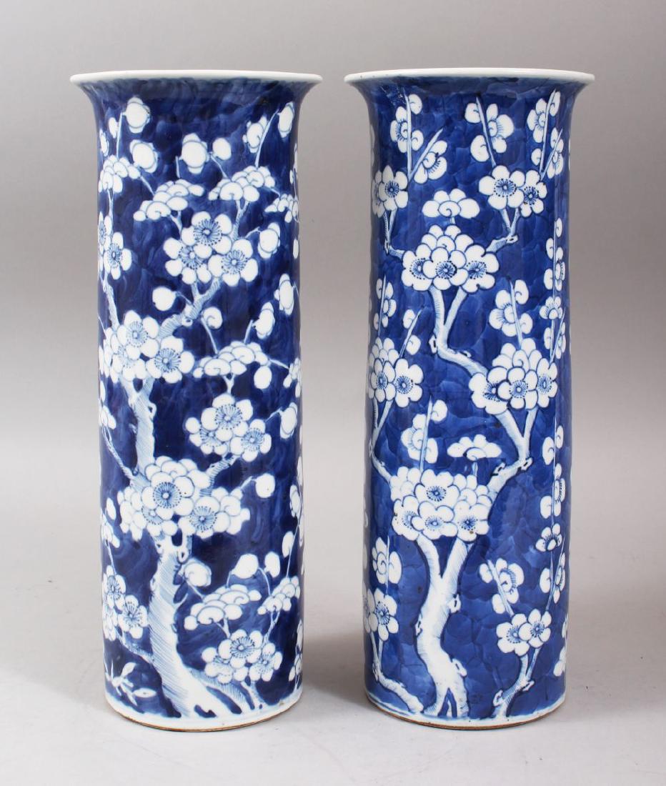A PAIR OF 19TH CENTURY CHINESE BLUE & WHITE PORCELAIN: A PAIR OF 19TH CENTURY CHINESE BLUE & WHITE PORCELAIN PRUNUS FLUTED VASES, the vases decorated with prunus decoration, the bases bearing four character kangxi marks, 30cm high x 12cm diameter.