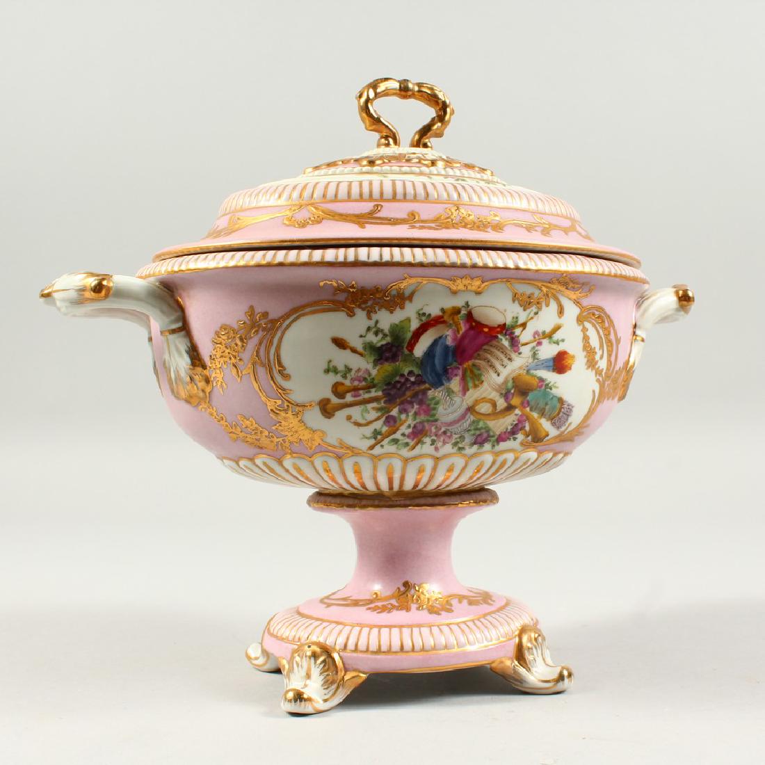 A PINK SEVRES DESIGN OVAL TWO HANDLED TUREEN AND COVER: A PINK SEVRES DESIGN OVAL TWO HANDLED TUREEN AND COVER painted with flowers and musical trophies. 10ins wide.