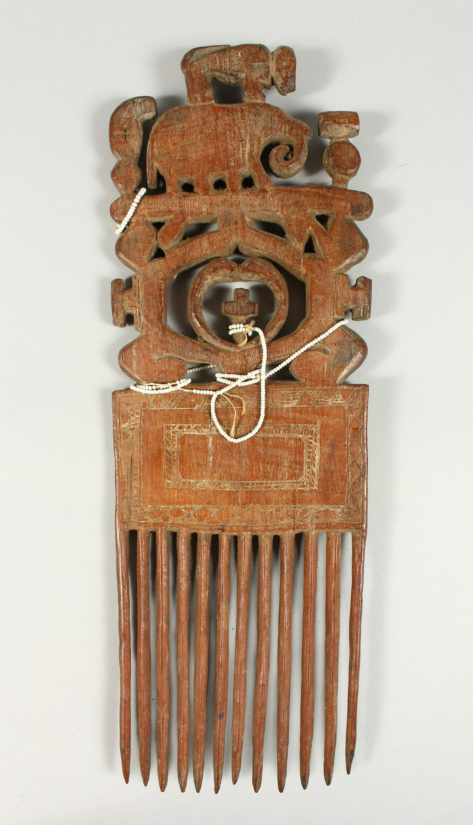 A TRIBAL CARVED WOOD COMB, monkey on an elephant.: A TRIBAL CARVED WOOD COMB, monkey on an elephant. 41cms high.