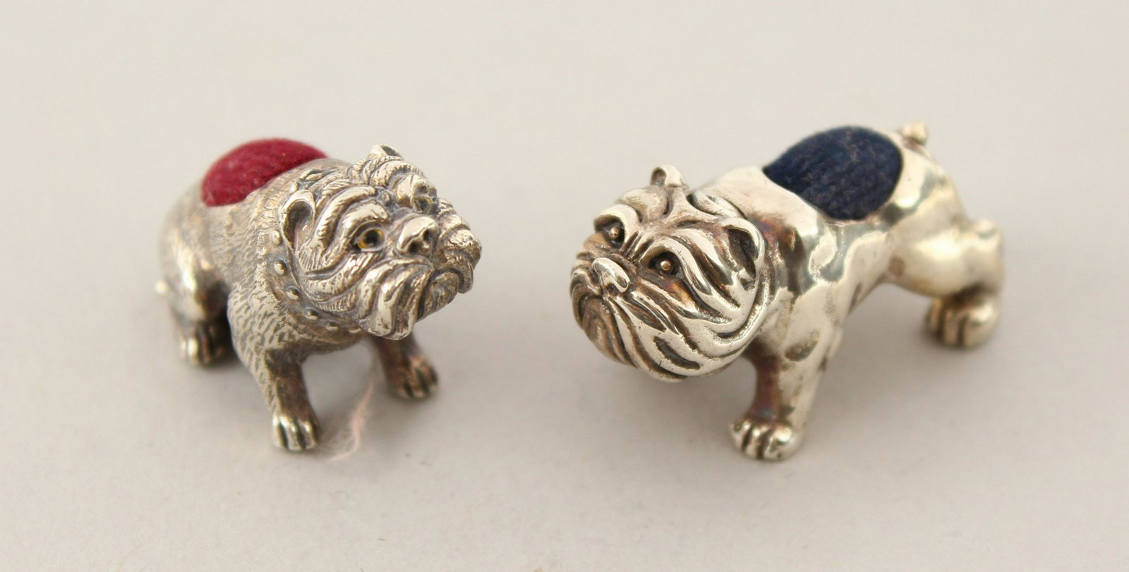 TWO CAST SILVER BULLDOG PIN CUSHIONS.: TWO CAST SILVER BULLDOG PIN CUSHIONS.