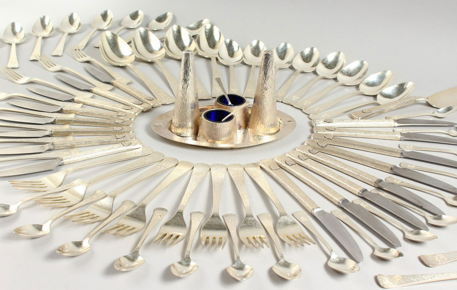 A SUPERB SILVER CANTEEN OF CUTLERY by JACK SPENCER with: A SUPERB SILVER CANTEEN OF CUTLERY by JACK SPENCER with family crest, silver cutlery comprising four large serving spoons, eight tablespoons, eight dessert spoons, eight teaspoons, eight egg spoons, e