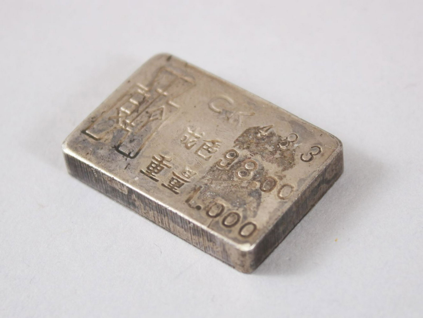 A GOOD CHINESE WHITE METAL WEIGHT, the rear with: A GOOD CHINESE WHITE METAL WEIGHT, the rear with inscriptions, the front with two roundel's of figures, 2cm x 3cm.
