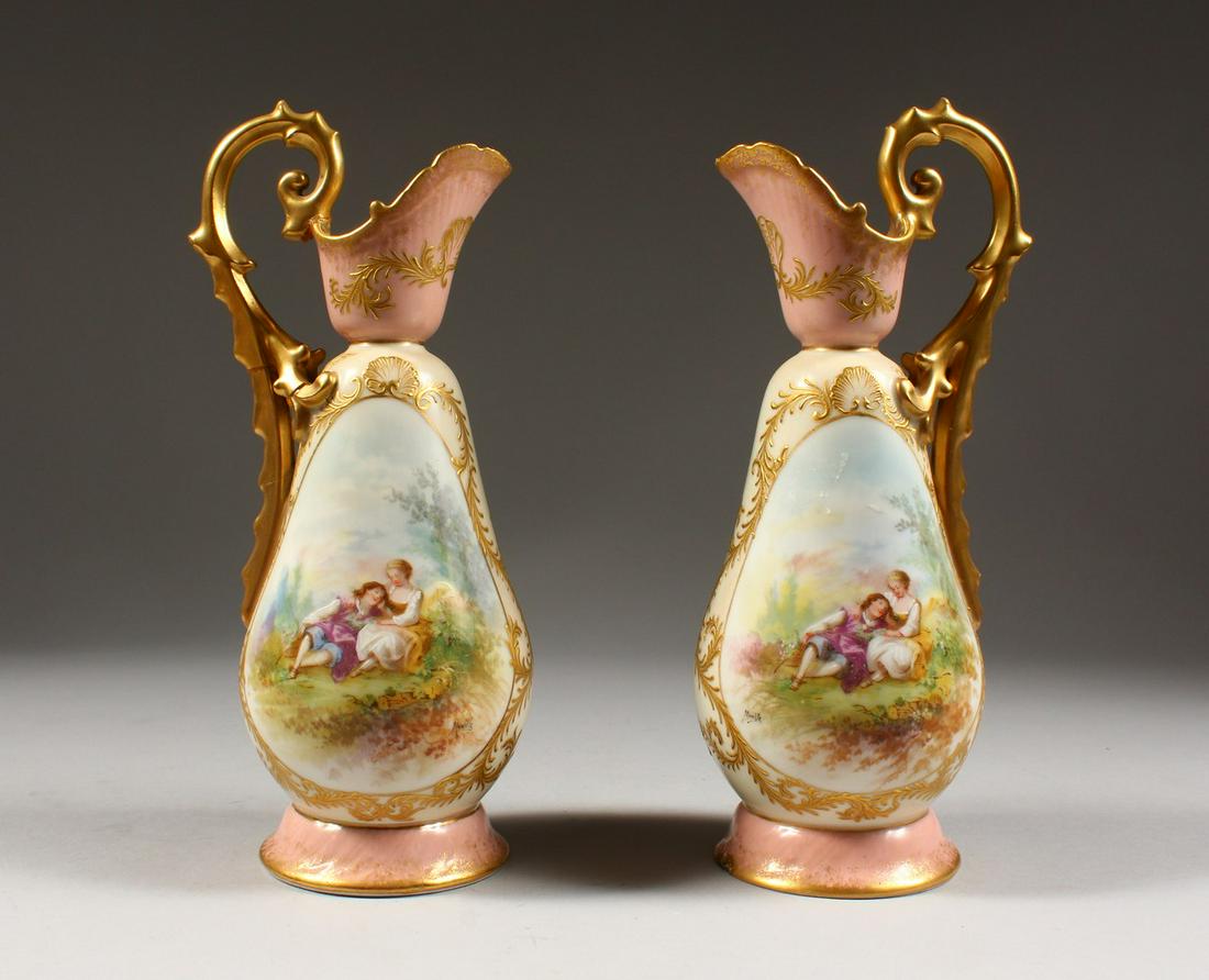 A PAIR OF SEVRES DESIGN EWERS, edged in gilt with: A PAIR OF SEVRES DESIGN EWERS, edged in gilt with panels of young lovers. 9.5ins high.