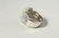 A LARGE SILVER CZ SET BUCKLE RING. - 2