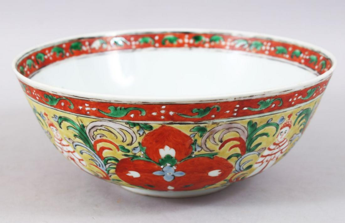 A 19TH / 20TH CENTURY CHINESE FAMILLE ROSE PORCELAIN: A 19TH / 20TH CENTURY CHINESE FAMILLE ROSE PORCELAIN BOWL, decorated on a yellow ground with figures amongst flora, the base with an iron red six-character mark, 23cm diameter.