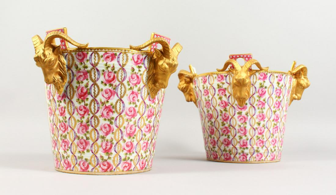 A VERY GOOD PAIR OF SEVRES PORCELAIN ICE PAILS, with: A VERY GOOD PAIR OF SEVRES PORCELAIN ICE PAILS, with bands of roses and four gilded rams masks. Sevres mark in blue. 8.5ins high x 8.25ins diameter.