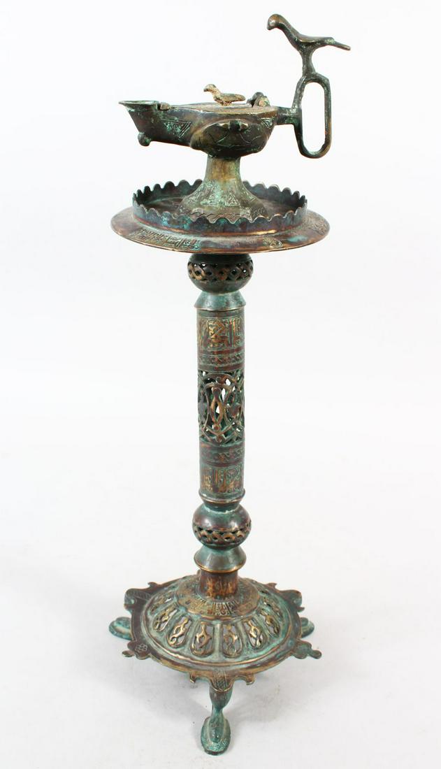 A 13TH CENTURY ISLAMIC BRONZE LAMP, the top with an: A 13TH CENTURY ISLAMIC BRONZE LAMP, the top with an Aladdin type lamp, 45cm high.