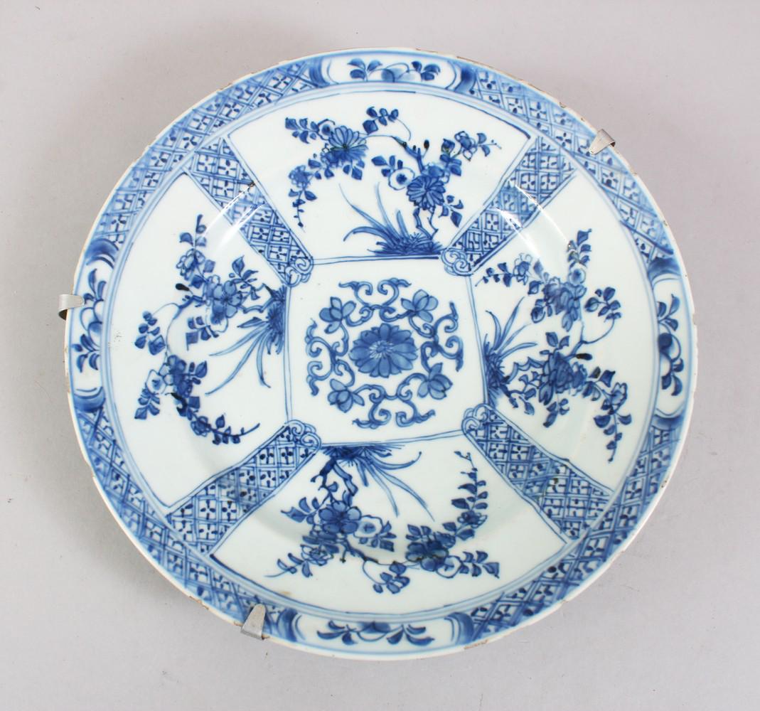 A 19TH CENTURY CHINESE BLUE & WHITE PORCELAIN PLATE,: A 19TH CENTURY CHINESE BLUE & WHITE PORCELAIN PLATE, with panels of floral decoration, with a metal wall hanging, 23cm diameter.