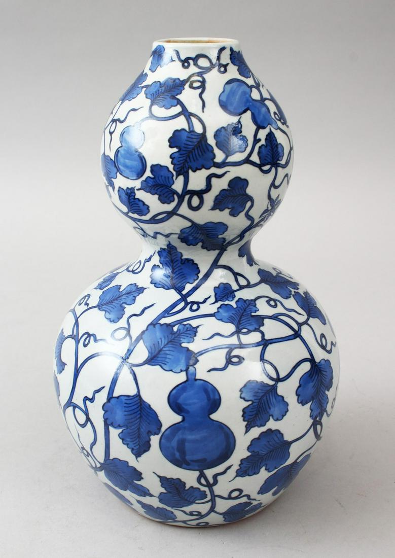 A GOOD CHINESE BLUE & WHITE DOUBLE GOURD PORCELAIN: A GOOD CHINESE BLUE & WHITE DOUBLE GOURD PORCELAIN VASE, the body of the vase decorated with fruit and vine decoration, 24cm high.