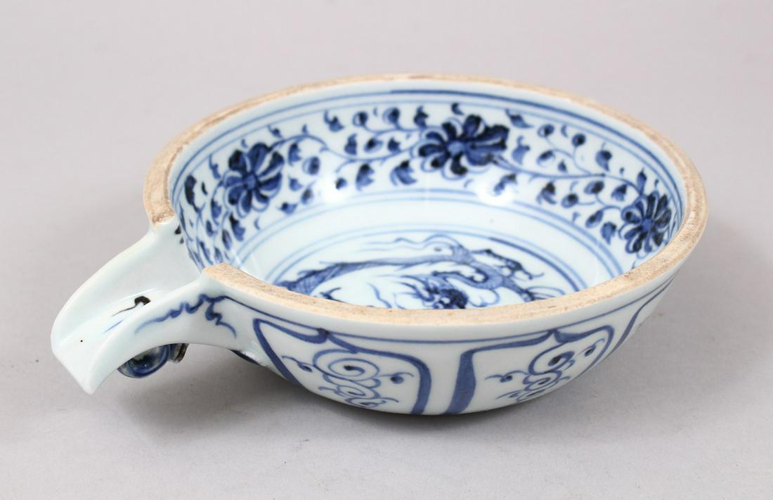 A CHINESE MING STYLE BLUE & WHITE PORCELAIN OIL POT,: A CHINESE MING STYLE BLUE & WHITE PORCELAIN OIL POT, the body decorated with scenes of dragons amongst native flora, base unglazed, 17.5cm diameter including pourer.