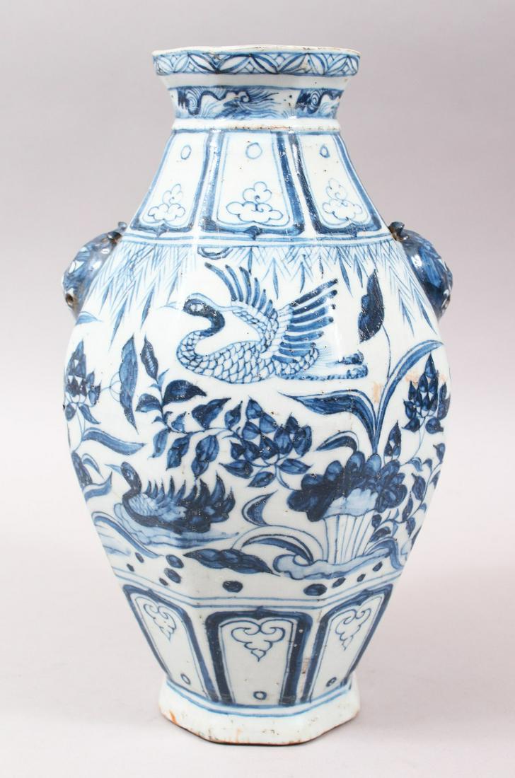 A CHINESE MING STYLE BLUE & WHITE TWIN HANDLE PORCELAIN: A CHINESE MING STYLE BLUE & WHITE TWIN HANDLE PORCELAIN VASE, the body with twin moulded lion dog mask handles, further decorated with birds amongst native landscape scenes, the base unglazed. 29cm hi