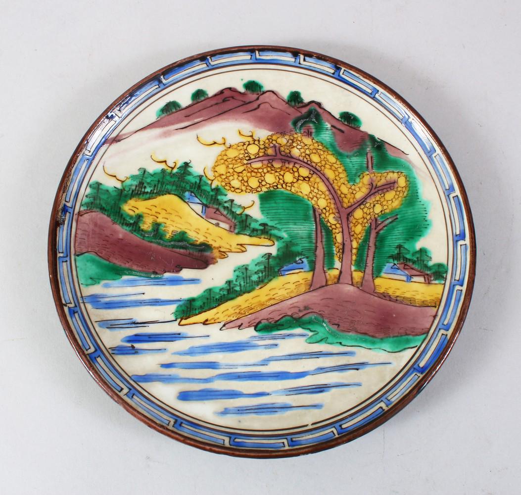 A GOOD JAPANESE MEIJI PERIOD IMARI PORCELAIN PLATE,: A GOOD JAPANESE MEIJI PERIOD IMARI PORCELAIN PLATE, decorated in four colour decoration to depict a landscape scene, the underside with green glaze and a green glazed signature, 20.5cm diameter.