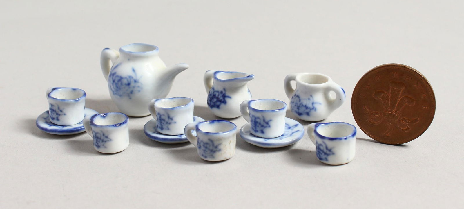 A MINIATURE BLUE AND WHITE TEA SET with teapot, milk: A MINIATURE BLUE AND WHITE TEA SET with teapot, milk jug, sugar basin, six cups and three saucers.