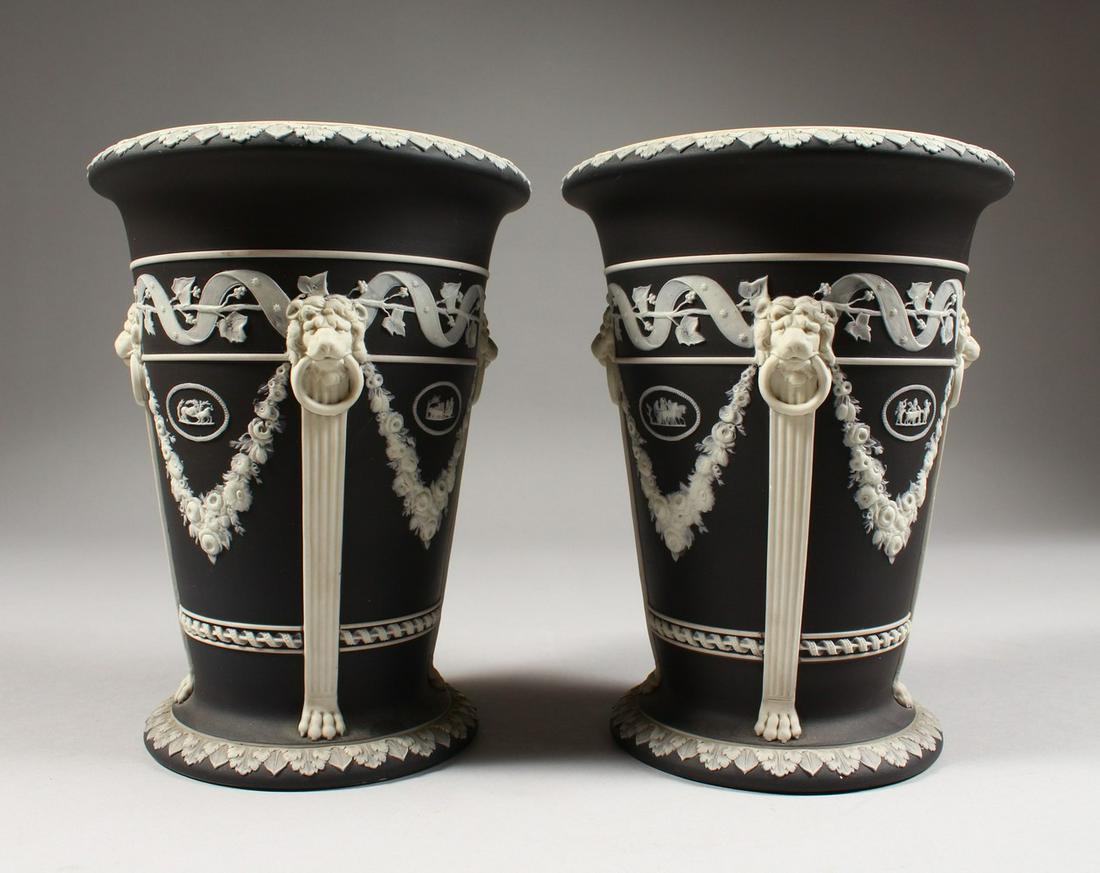 A PAIR OF WEDGWOOD BLACK AND WHITE JASPER WARE VASES,: A PAIR OF WEDGWOOD BLACK AND WHITE JASPER WARE VASES, with lion ring handles, medallions and garlands. Impressed WEDGWOOD. 7ins high.