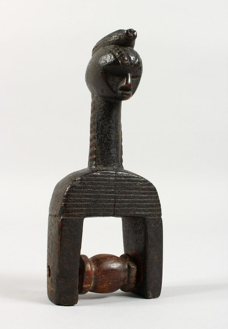 A CARVED WOOD TRIBAL HEDLEY PULLEY. 6.5ins high.: A CARVED WOOD TRIBAL HEDLEY PULLEY. 6.5ins high.