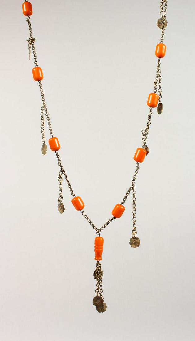 A CHINESE CARVED AMBER BEAD AND WHITE METAL NECKLACE,: A CHINESE CARVED AMBER BEAD AND WHITE METAL NECKLACE, 104CM LONG.