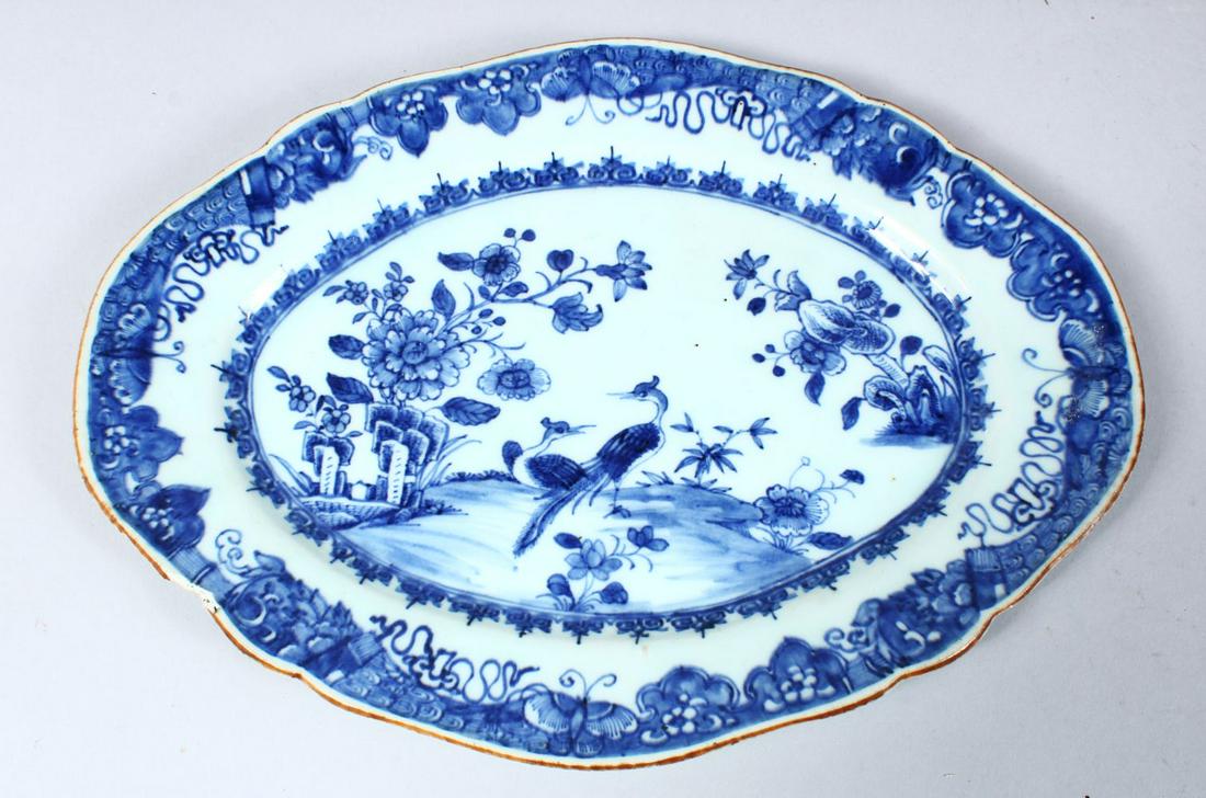 A 19TH CENTURY CHINESE BLUE & WHITE PORCELAIN SERVING: A 19TH CENTURY CHINESE BLUE & WHITE PORCELAIN SERVING DISH, decorated with peacocks amongst native flora with butterfly borders, 25cm high x 34cm wide.