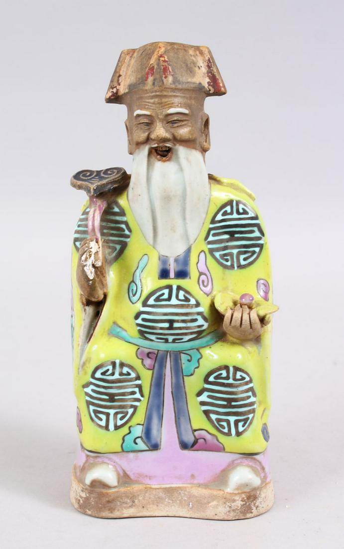 A 18TH CENTURY CHINESE FAMILLE ROSE PORCELAIN FIGURE OF: A 18TH CENTURY CHINESE FAMILLE ROSE PORCELAIN FIGURE OF AN IMMORTAL, wearing traditional attire, holding a ruyi scepter and fruit, 21cm high x 9.5cm wide.`