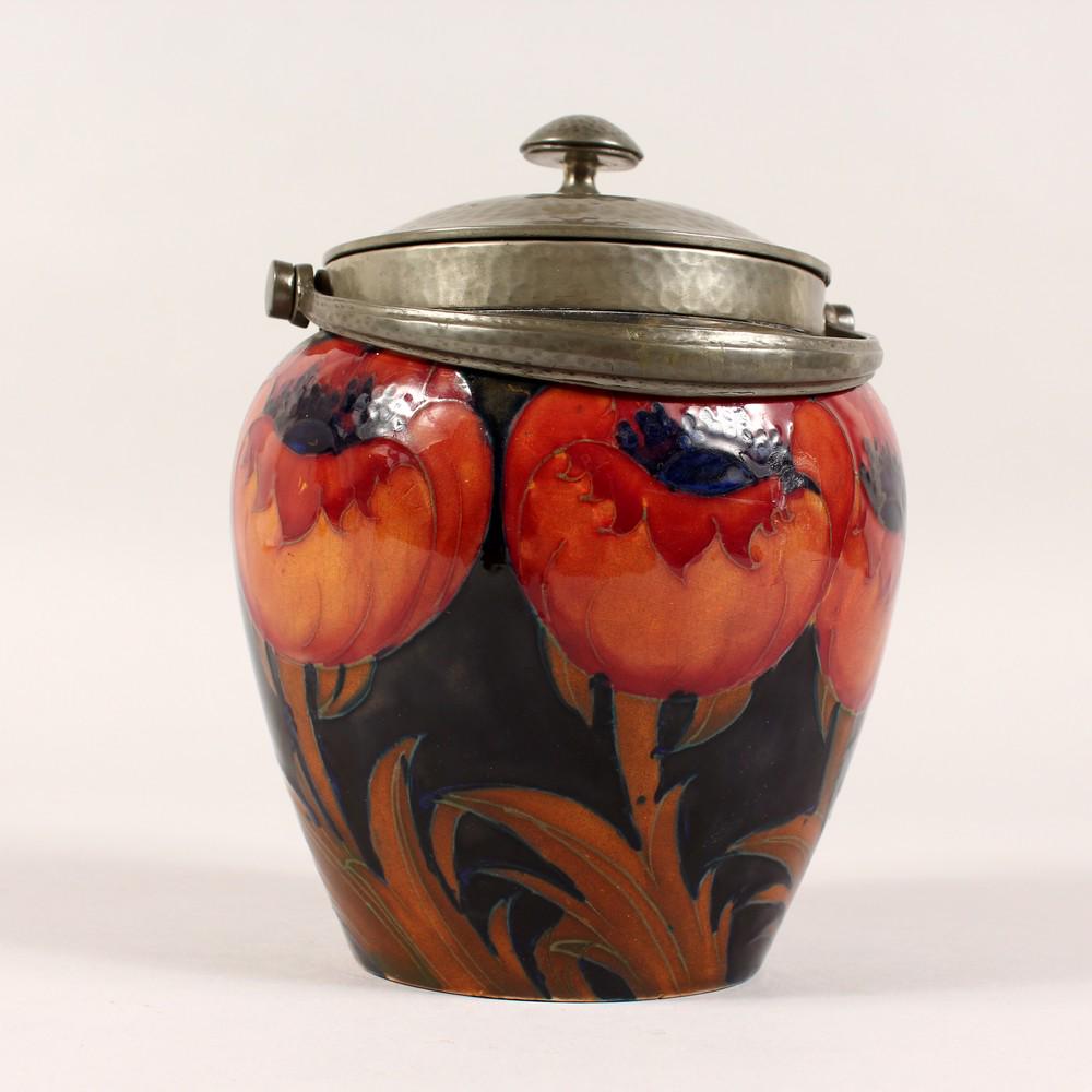 A GOOD MOORCROFT BIG POPPY BISCUIT JAR AND COVER with: A GOOD MOORCROFT BIG POPPY BISCUIT JAR AND COVER with TUDRIC hammered pewter lid and handle. Impressed Moorcroft mark. 5.5ins high. Bears part of old label.