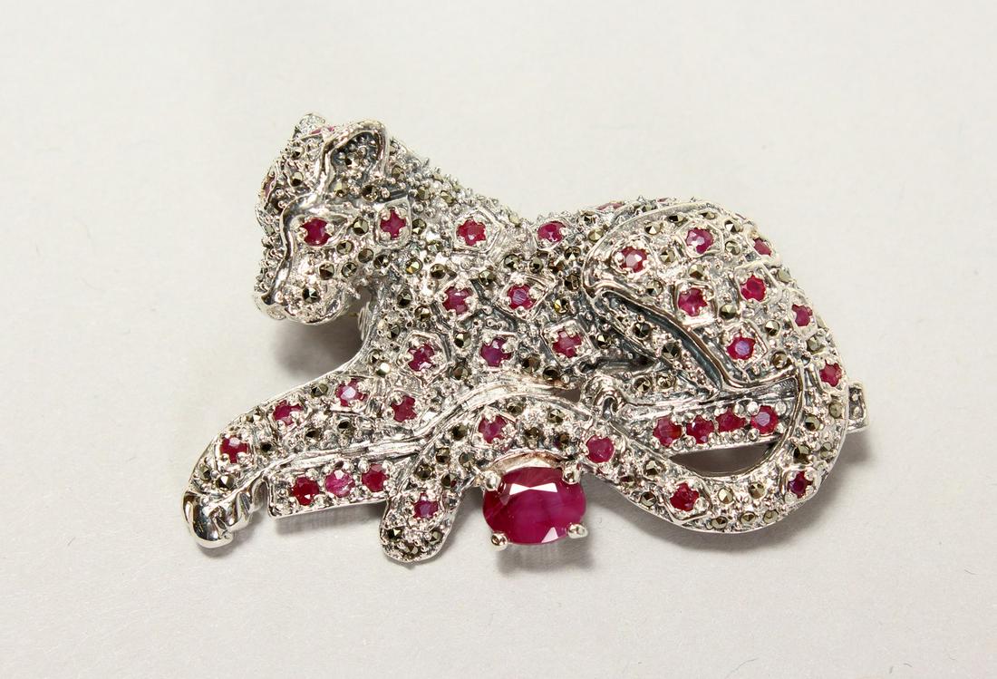 A SILVER PANTHER BROOCH, set with ruby and marcasite.: A SILVER PANTHER BROOCH, set with ruby and marcasite.
