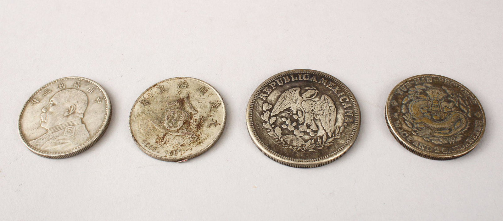 FOUR CHINESE WHITE METAL CURRENCY COINS, 4.5cm, 3.8cm: FOUR CHINESE WHITE METAL CURRENCY COINS, 4.5cm, 3.8cm the remaining three.(4)
