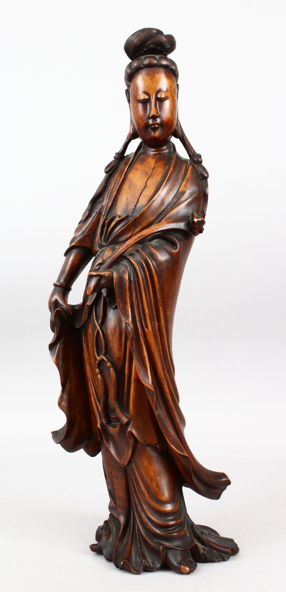A GOOD 19TH CENTURY CHINESE CARVED HARDWOOD FIGURE OF: A GOOD 19TH CENTURY CHINESE CARVED HARDWOOD FIGURE OF GUANYIN, stood in traditional attire and holding a ruyi scepter, 55cm high.
