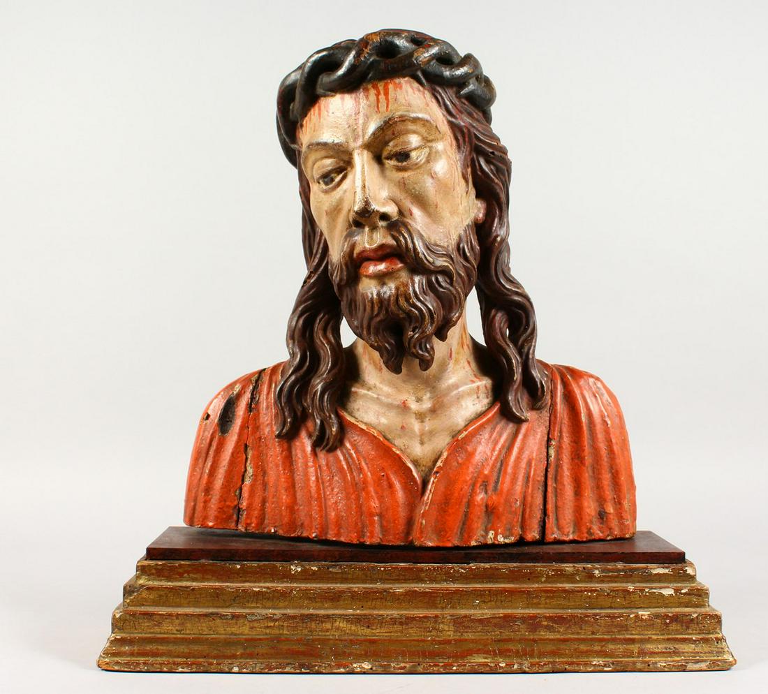 A 16TH/17TH CENTURY CARVED WOOD AND POLYCHROME PAINTED: A 16TH/17TH CENTURY CARVED WOOD AND POLYCHROME PAINTED BUST OF CHRIST, on a gilded, stepped wooden base. 18.5ins high.