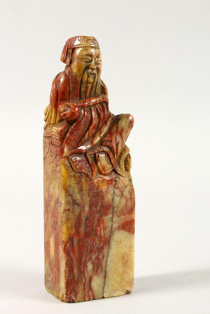 A GOOD 19TH CENTURY CARVED SOAPSTONE SEAL OF AN: A GOOD 19TH CENTURY CARVED SOAPSTONE SEAL OF AN IMMORTAL, the stone carved to depict a seated immortal figure, the base uncarved, 11.5cm high.