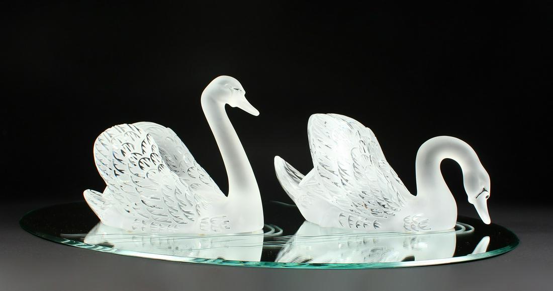 A SUPERB LALIQUE SWAN TABLE CENTREPIECE formed as two: A SUPERB LALIQUE SWAN TABLE CENTREPIECE formed as two swans, 14ins long, standing on a large oval mirrored plateau, 32ins x 22ins. Engraved Lalique, France.