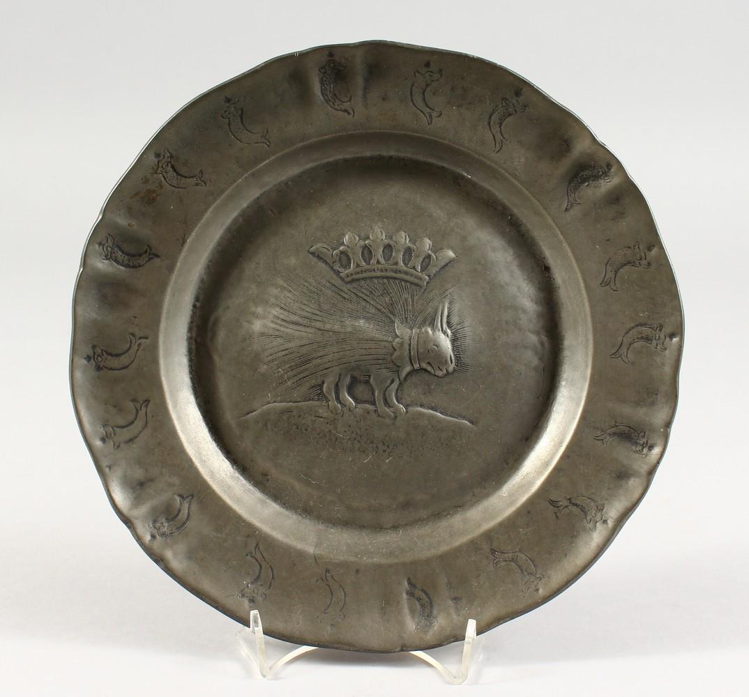 AN UNUSUAL PEWTER CIRCULAR DISH, the border with: AN UNUSUAL PEWTER CIRCULAR DISH, the border with dolphins. 9.5ins diameter.