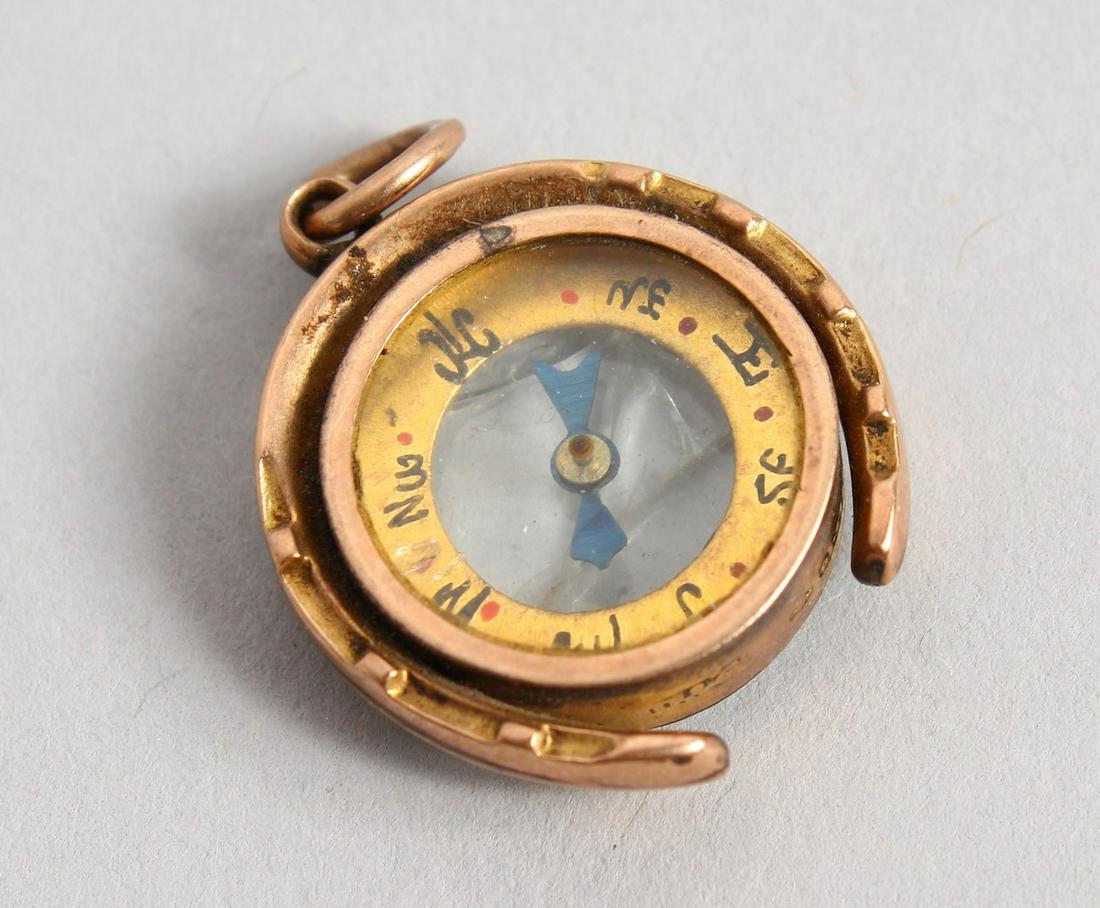 A SMALL GOLD COMPASS PENDANT.: A SMALL GOLD COMPASS PENDANT.